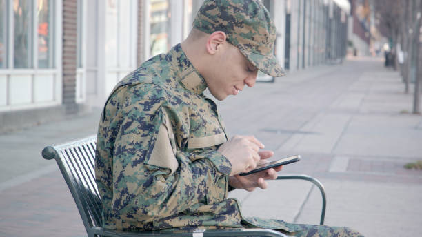 Military man texts using smart phone in the city